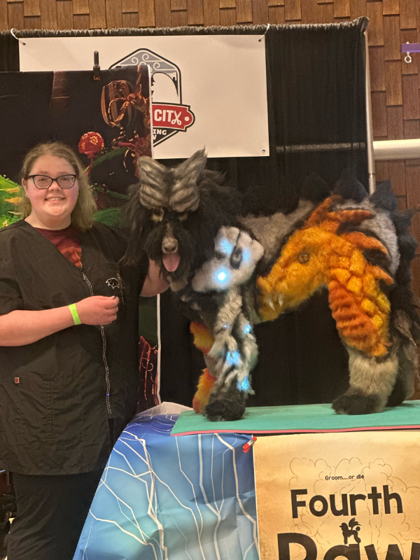 Groomer posing for photo with a groomed dog